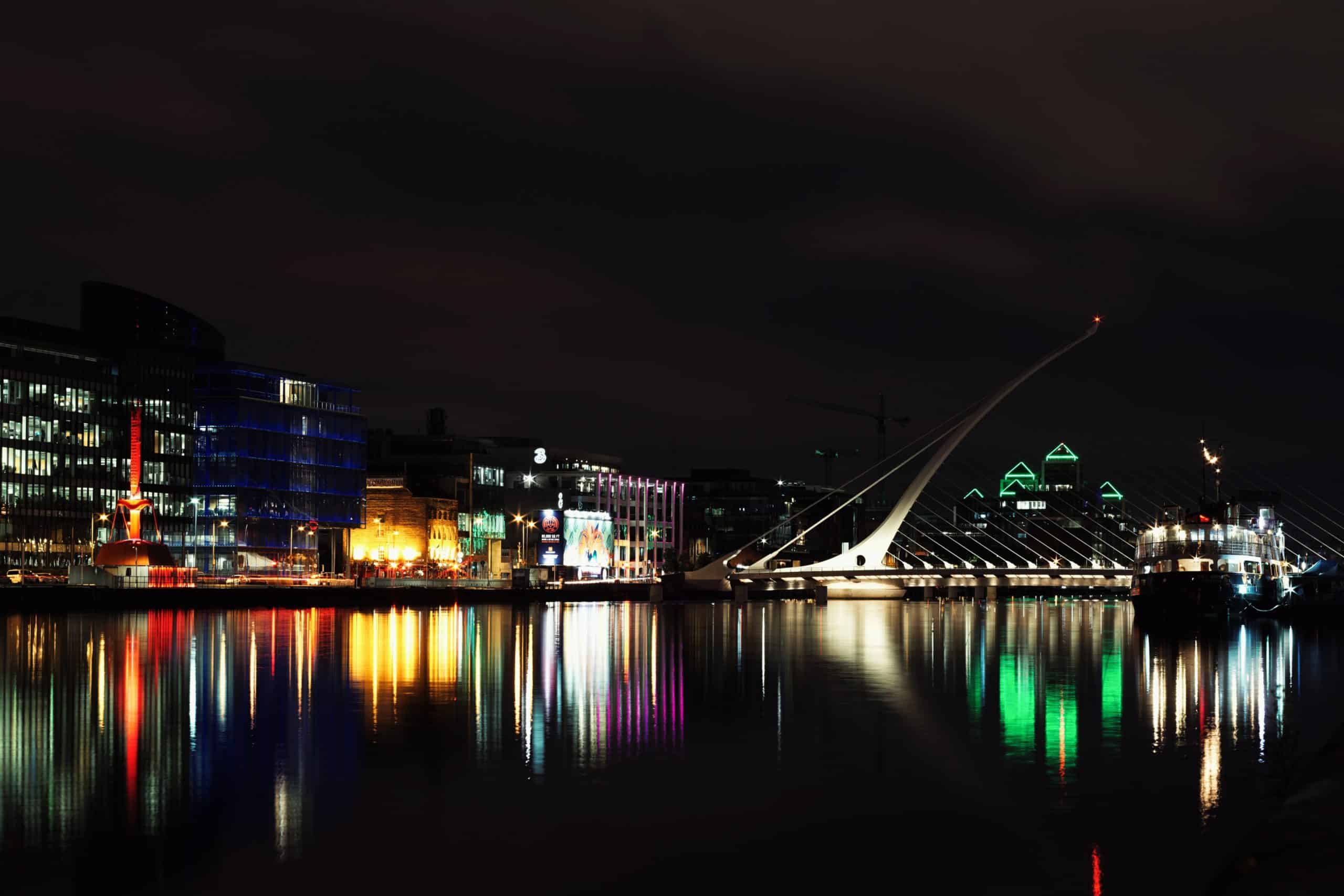 dublin at night time with city lights reflecting on the river liffey