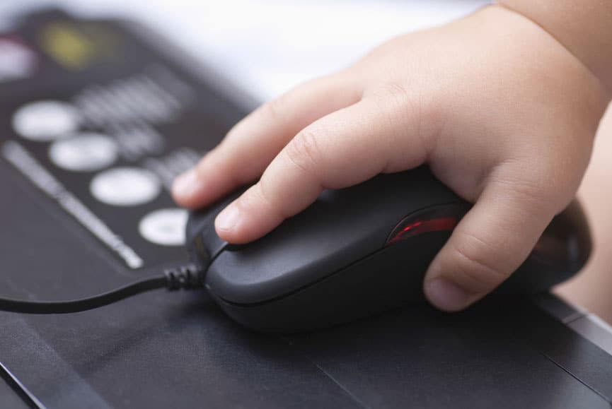 a baby holding a black computer mouse