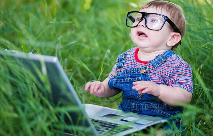 baby with glasses working on a laptop