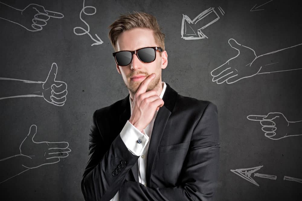 hiring a software developer with glasses standing in front of a black board