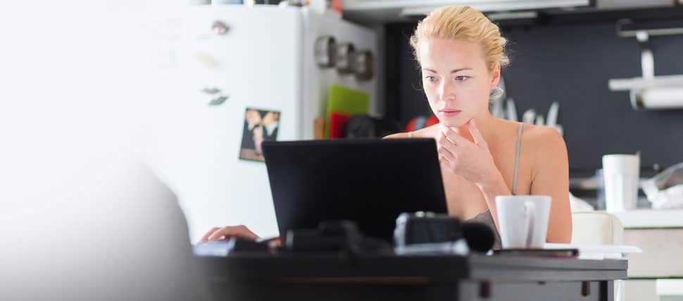 female software developer working remotely on her black laptop