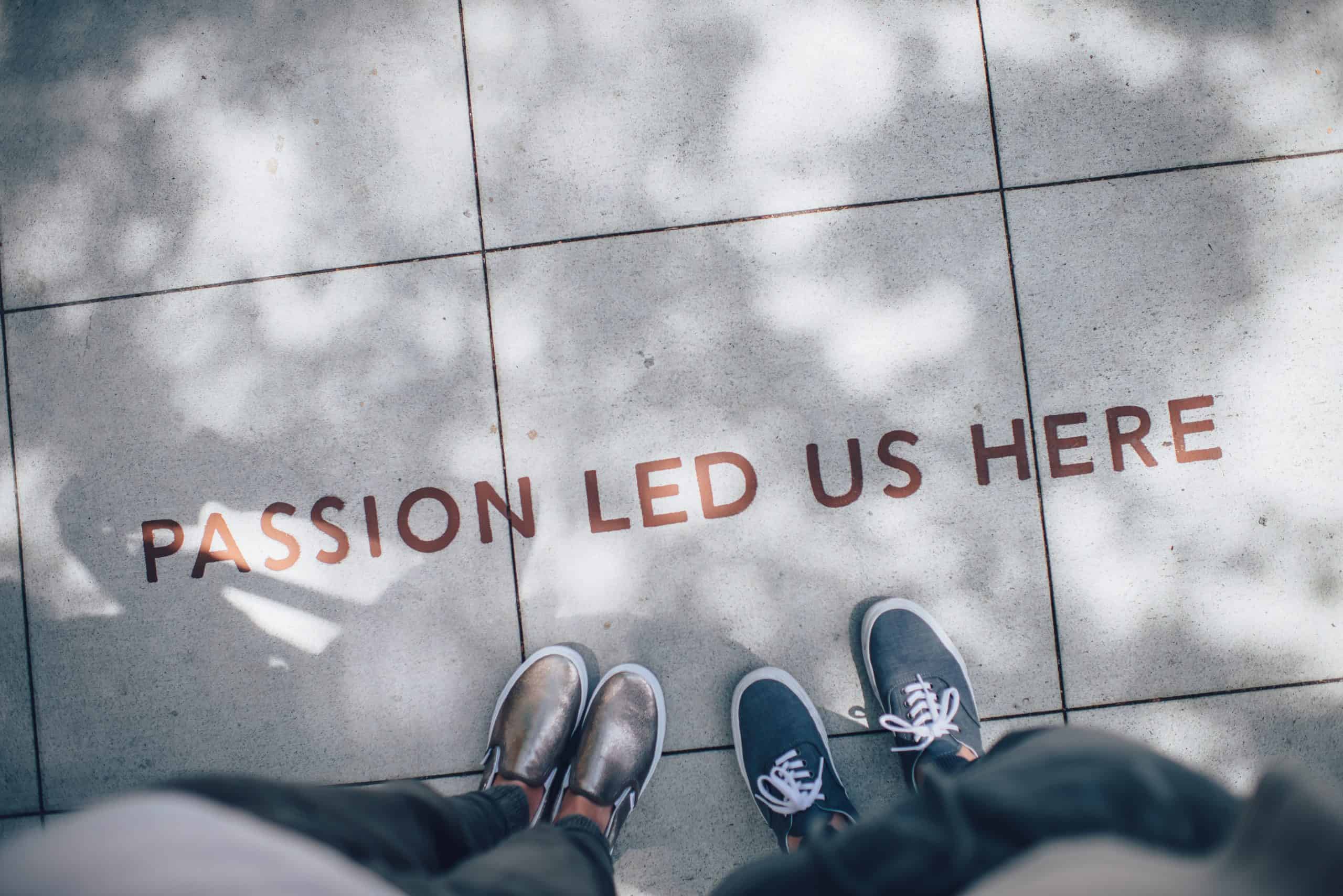 2 pairs of shoes with a sign on the floor that says "Passion led us here"