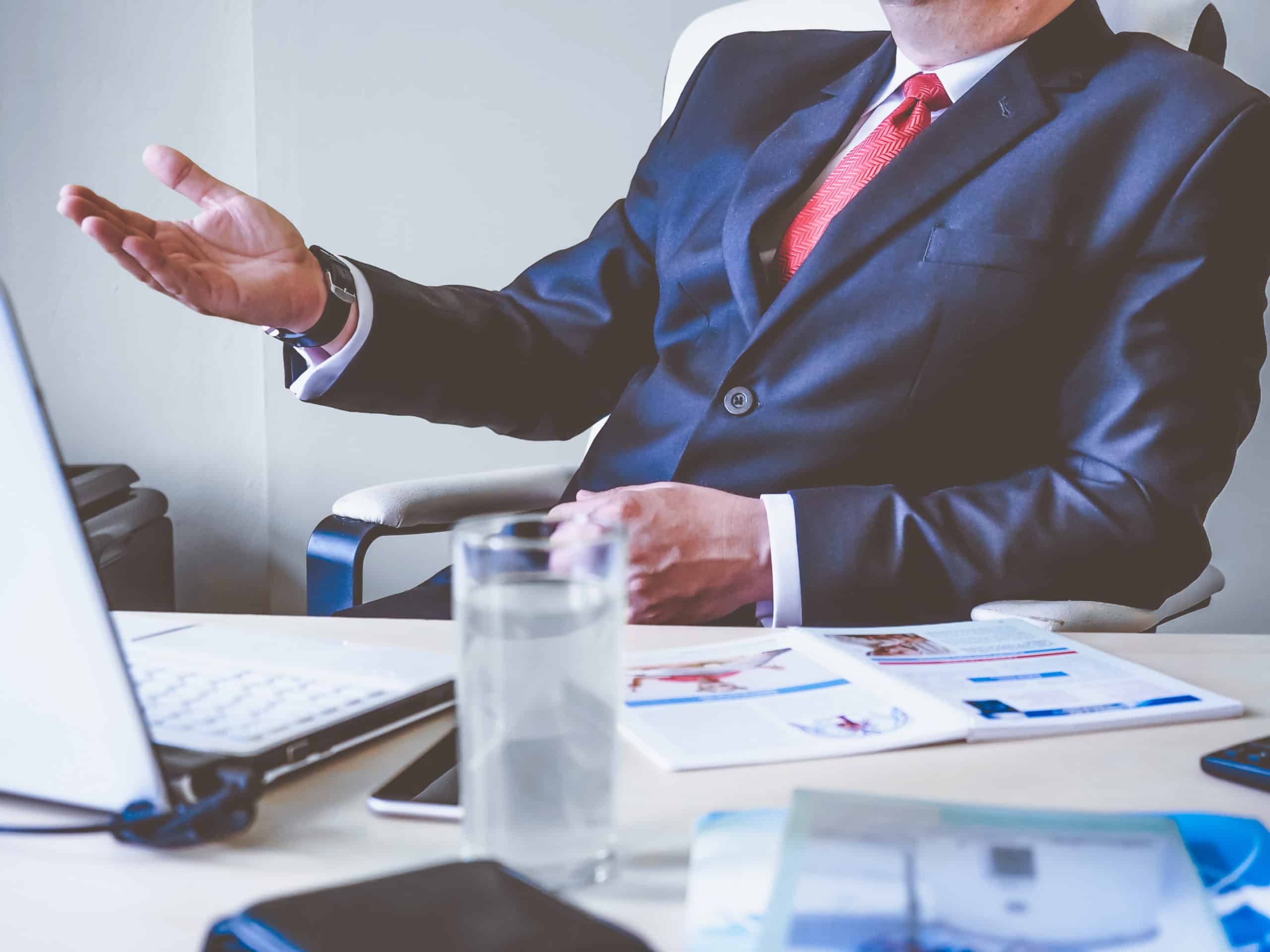 software consultant in a meeting over a desk with laptop and documents